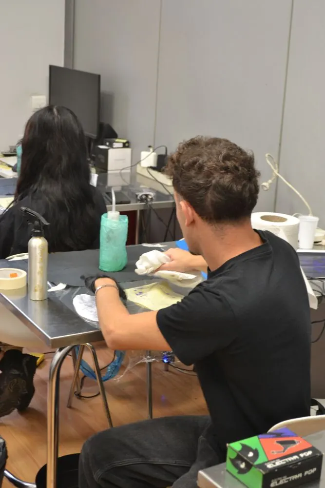 Alumnos practicando en las mesas del aula de tatuaje de EETP